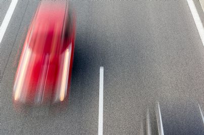 auto rossa che va molto veloce in strada